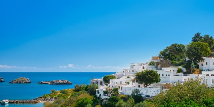 View of the bay and snow-white houses of the ancient city of Lindos on the Greek island of Rhodes, view of the Aegean Sea, the islands of the Dodecanese archipelago, Europe