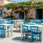 Beautiful wooden chairs and table in front of a beautiful old house under the sky