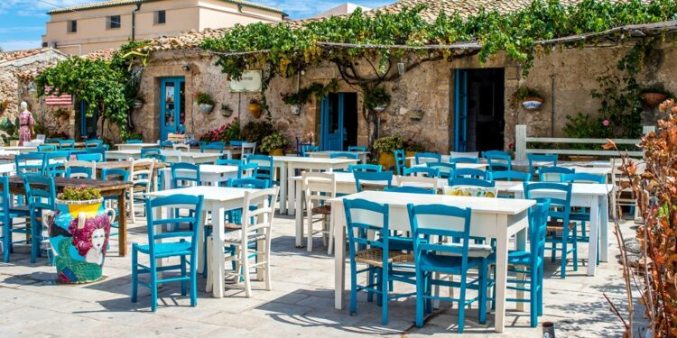 Beautiful wooden chairs and table in front of a beautiful old house under the sky
